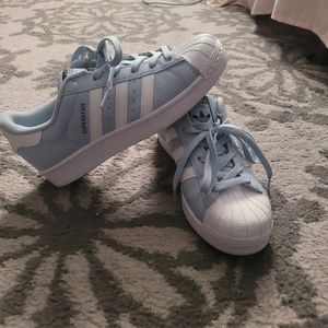 Baby blue Adidas superstar sneaker.